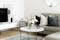 Runder Couchtisch mit Marmorplatte inmitten eines klassisch eingerichteten Wohnbereichs mit cosy Teppich und Musterkissen im Dreiergespann