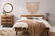 Schlafzimmer in neutralen Naturtönen mit Holzbett und Deko aus Seil an der Wand