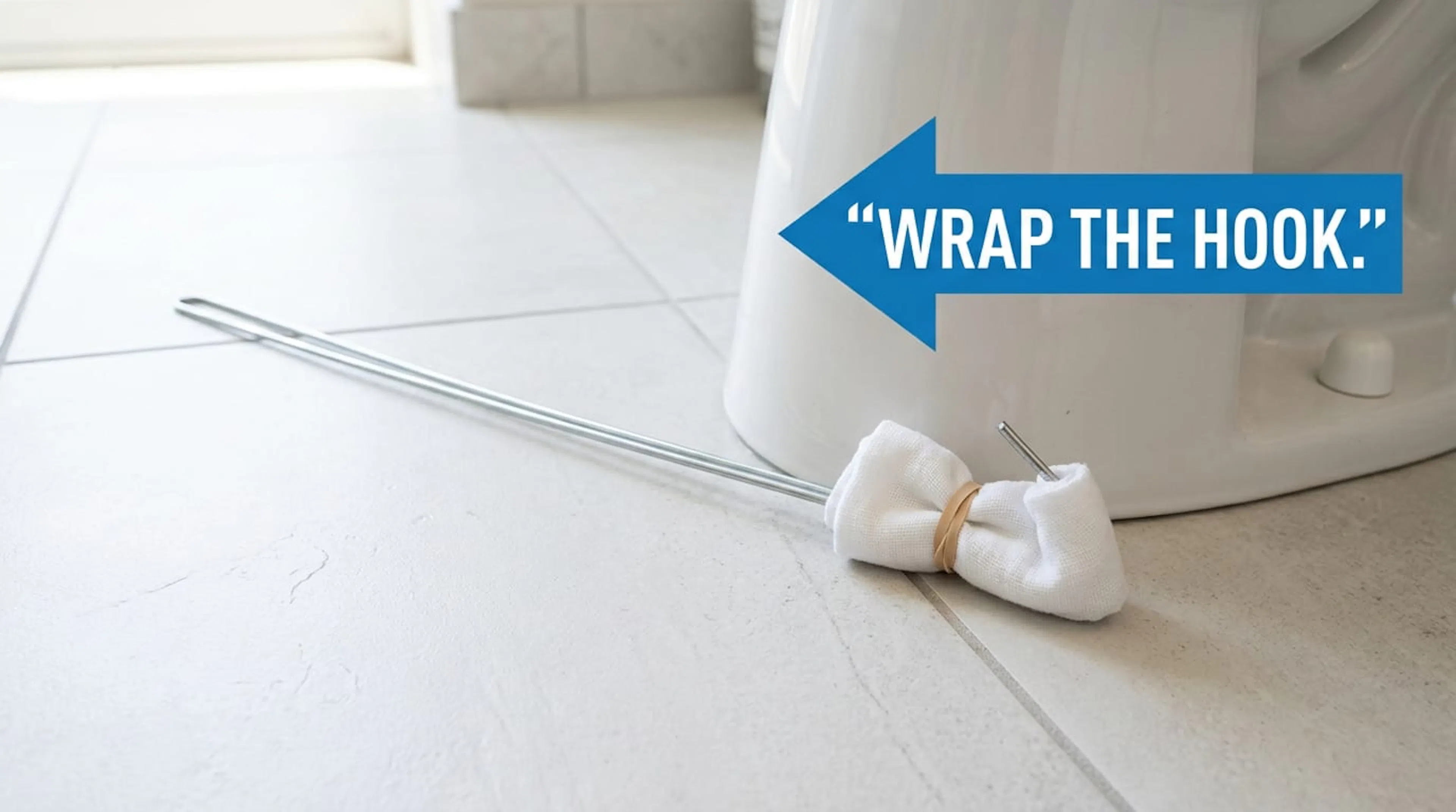 Cloth-wrapped coat-hanger hook beside a toilet