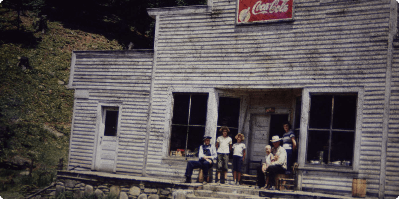 Folks standing on porch of old store