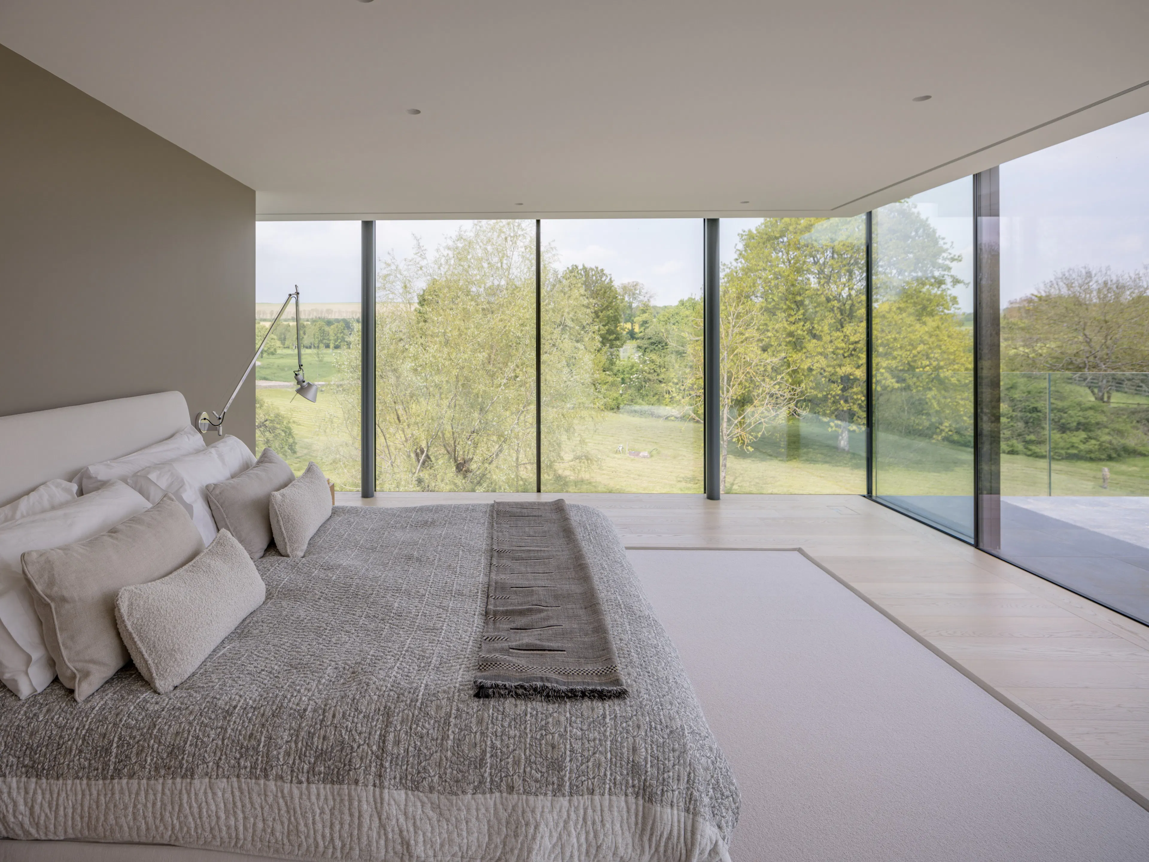 Bedroom in the glass wing with glazing on two sides and blinds concealed in the ceiling
