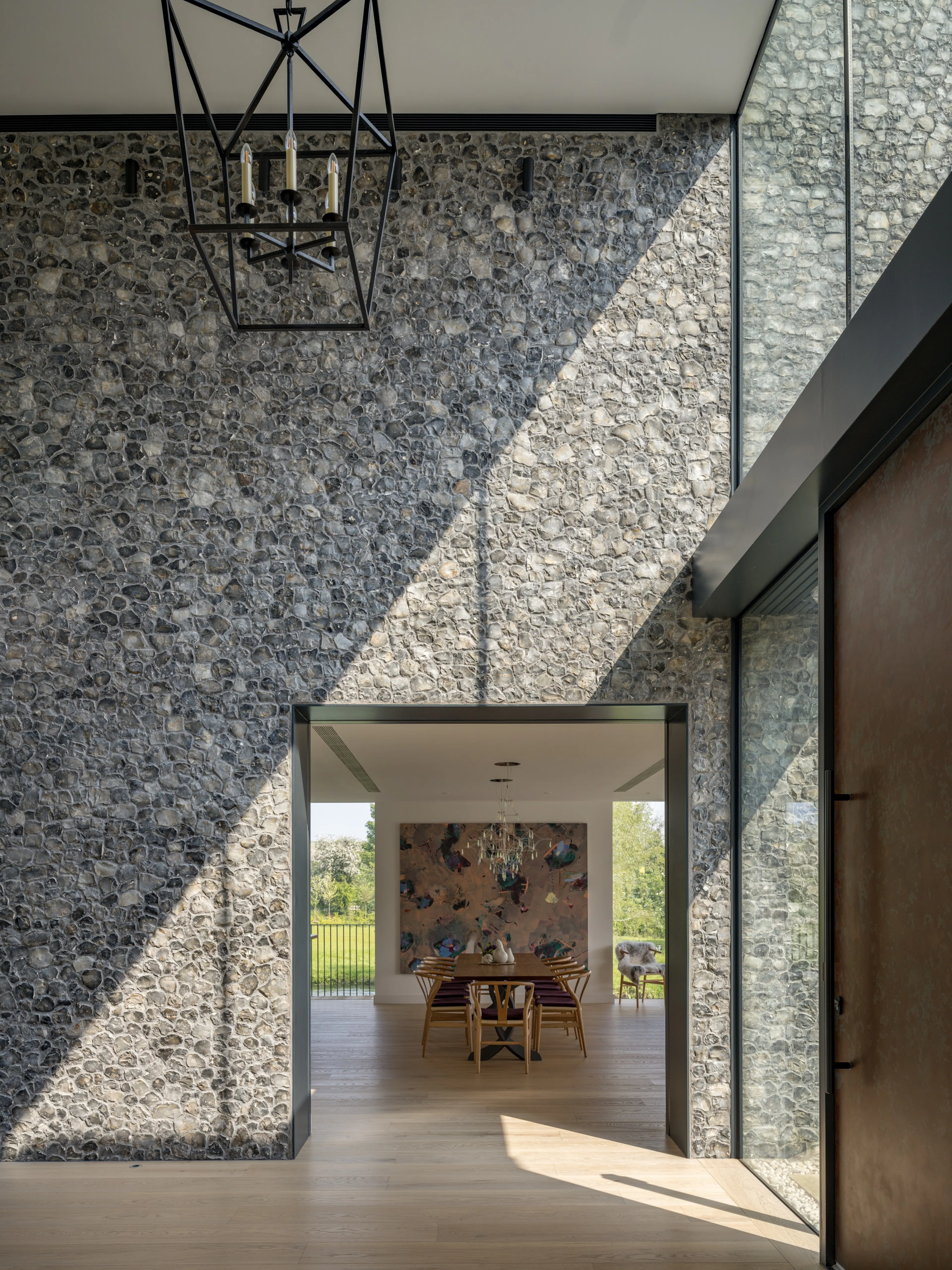 View from the hall between flint walls to the dining table and the garden beyond