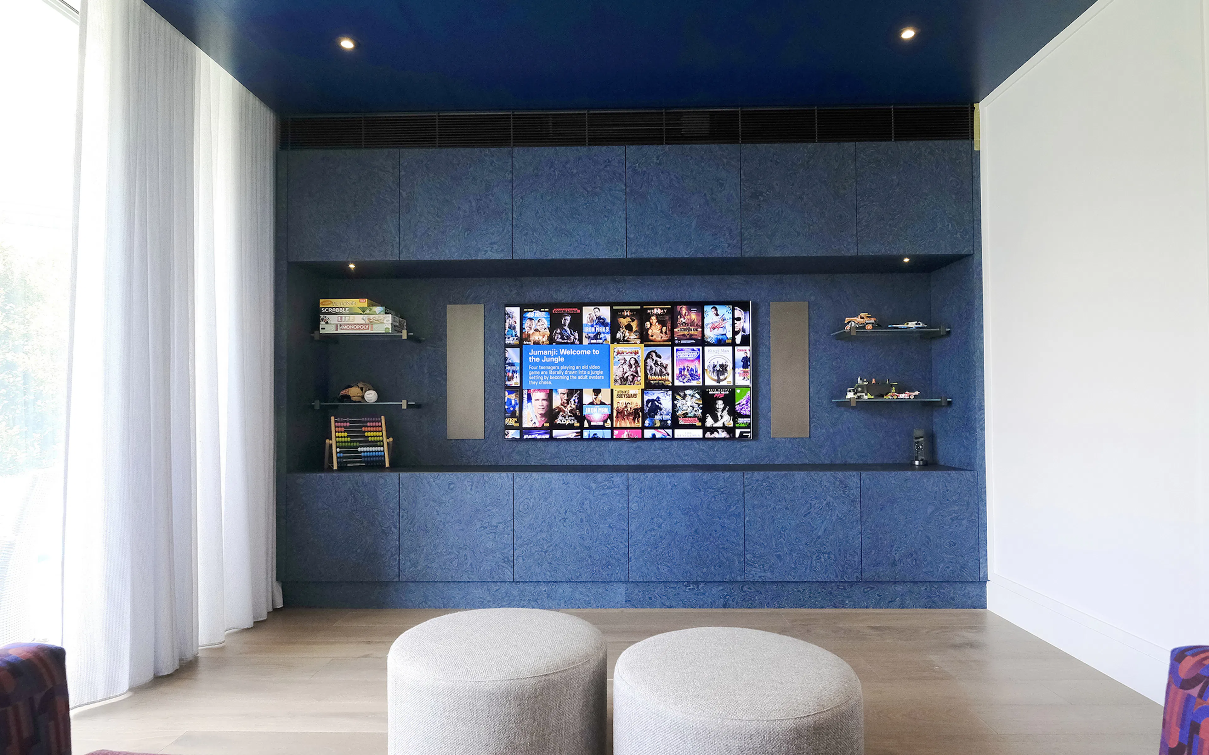 Meridian DSP730 in-wall loudspeakers either side of a television in blue joinery