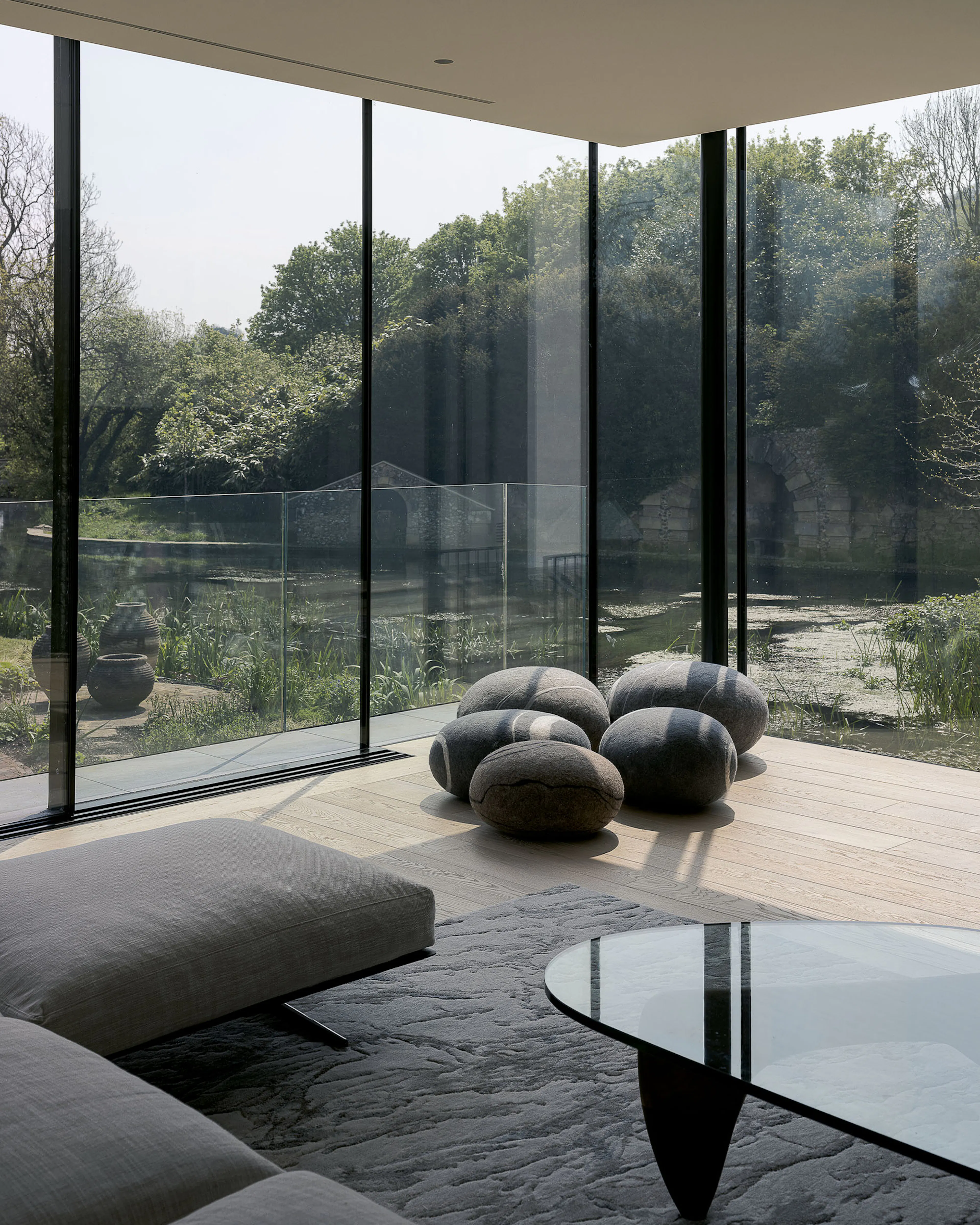 Glass-walled living room overlooking woodland, with no technology in sight