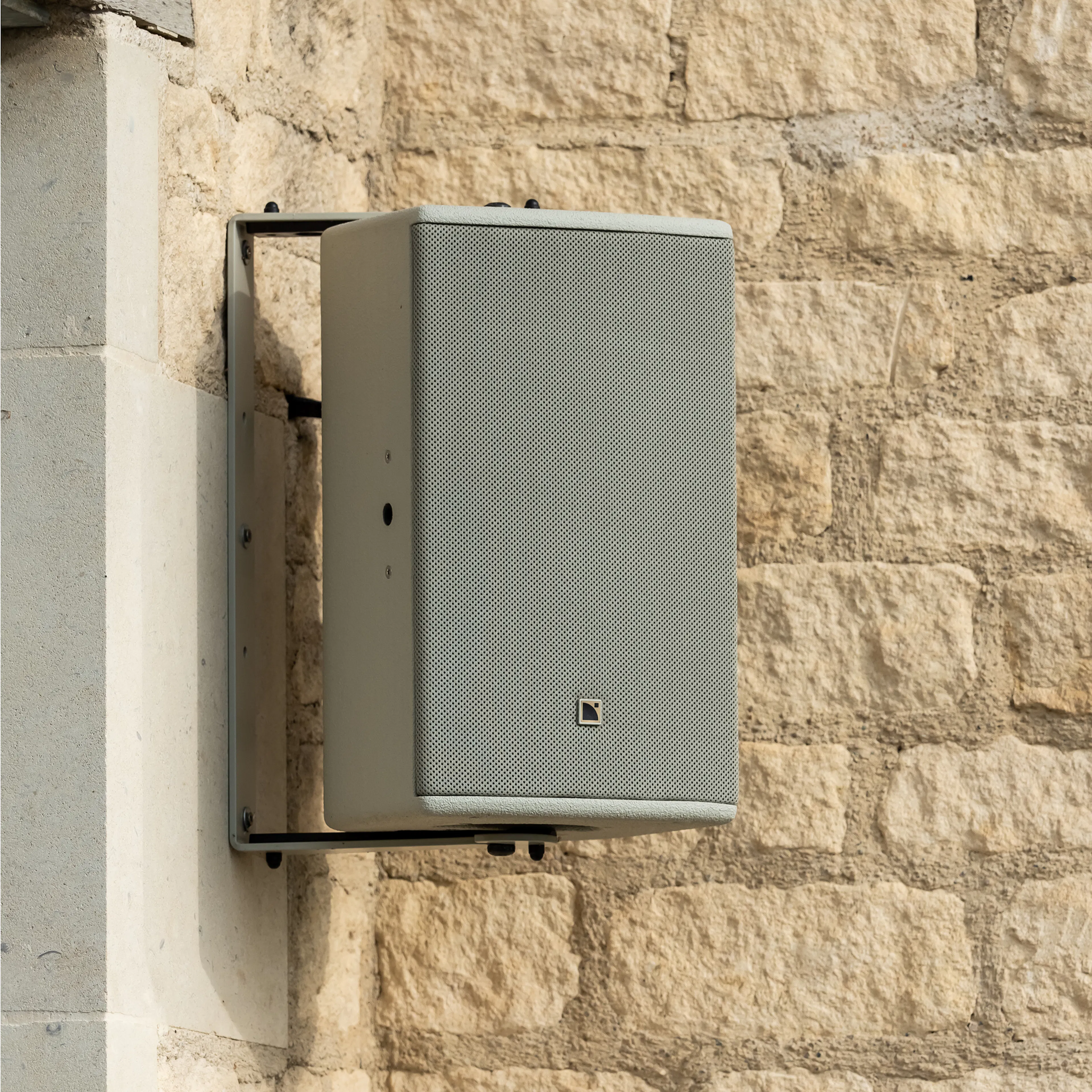 L-Acoustics X8 loudspeaker wall-mounted against Cotswold stone at Limeyard