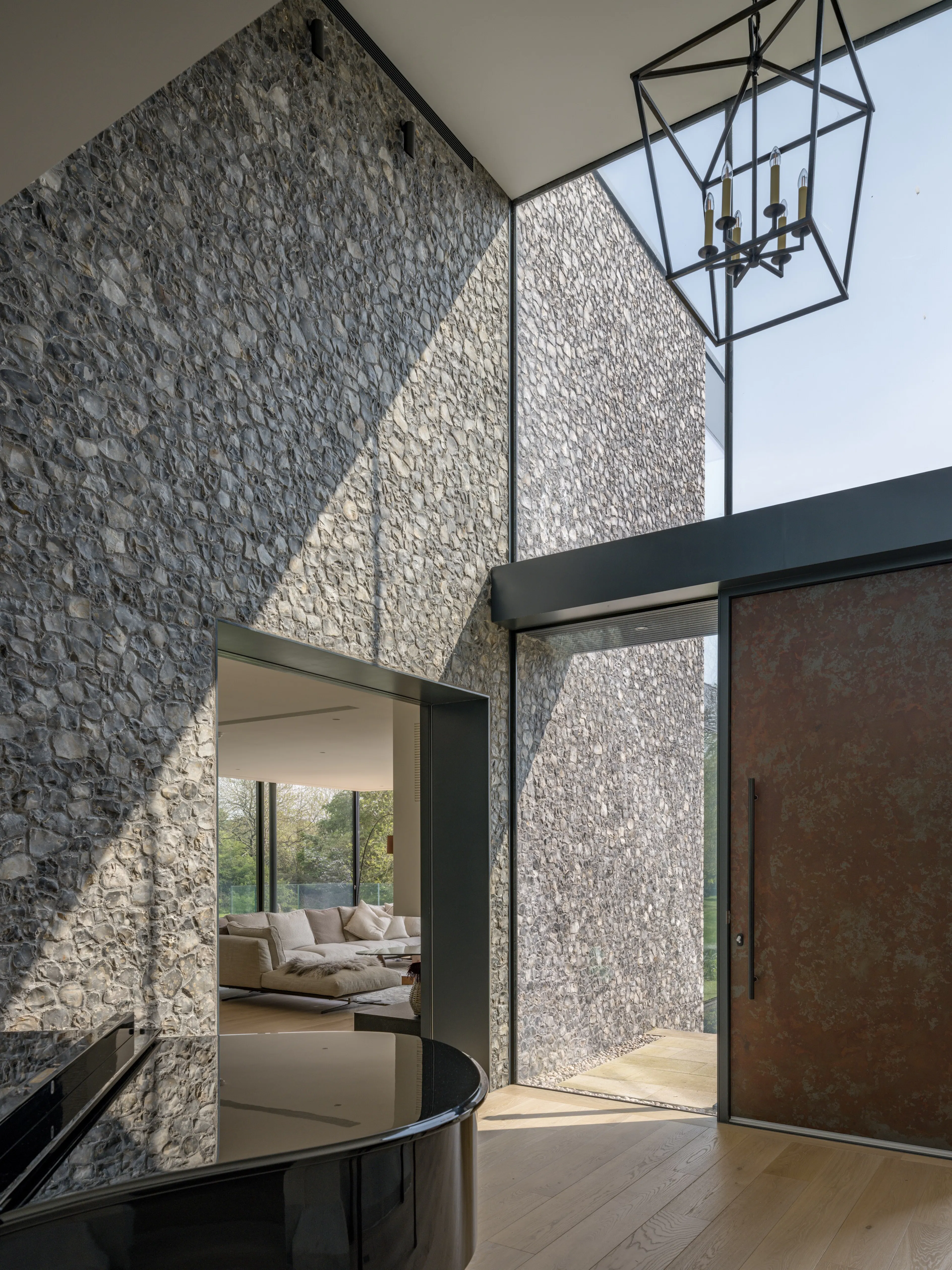 Hall with a lantern pendant and bronze front door, looking through to the sitting room