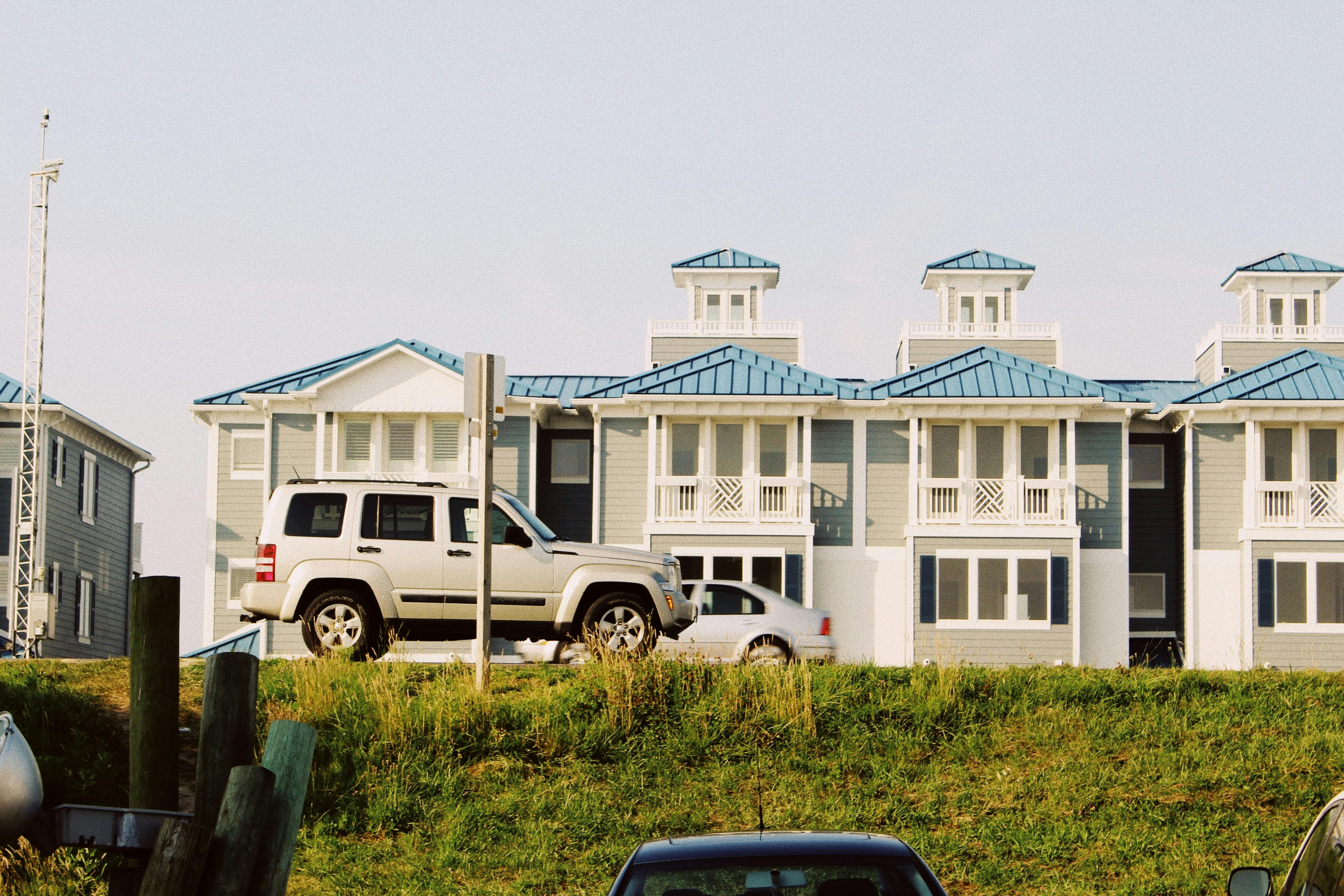 Cars passing townhomes, @simiiluyomade/Unsplash