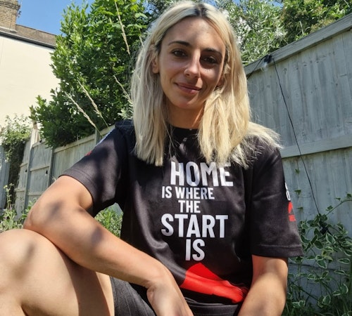 A woman in a T shirt that reads 'Home is where the start is'