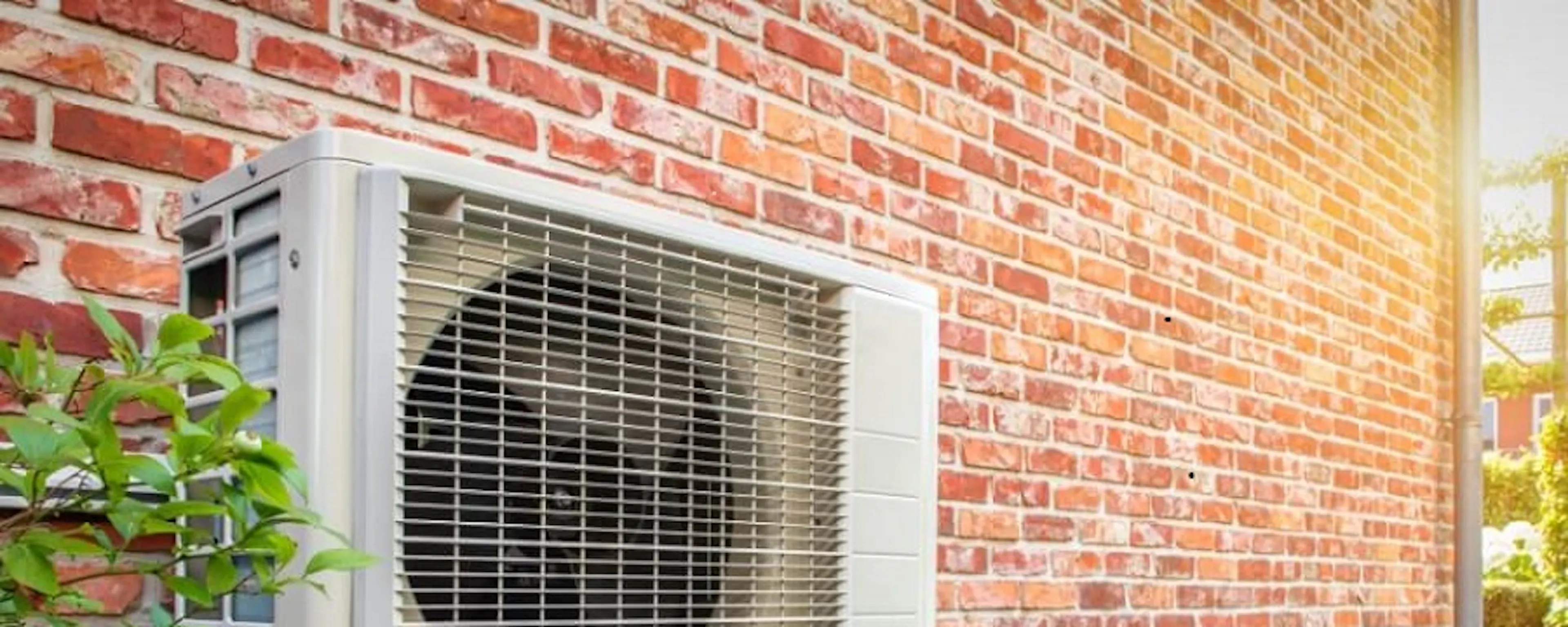 Unité extérieure de climatisation fixée sur un mur en briques