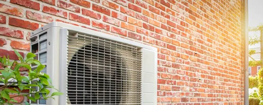 Unité extérieure de climatisation fixée sur un mur en briques