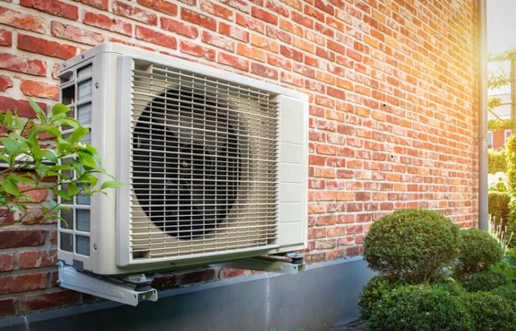 Unité extérieure de climatisation fixée sur un mur en briques
