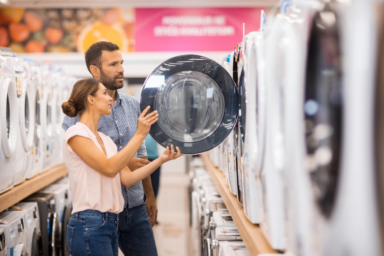 Couple choisissant un lave-linge dans un magasin d'électroménager