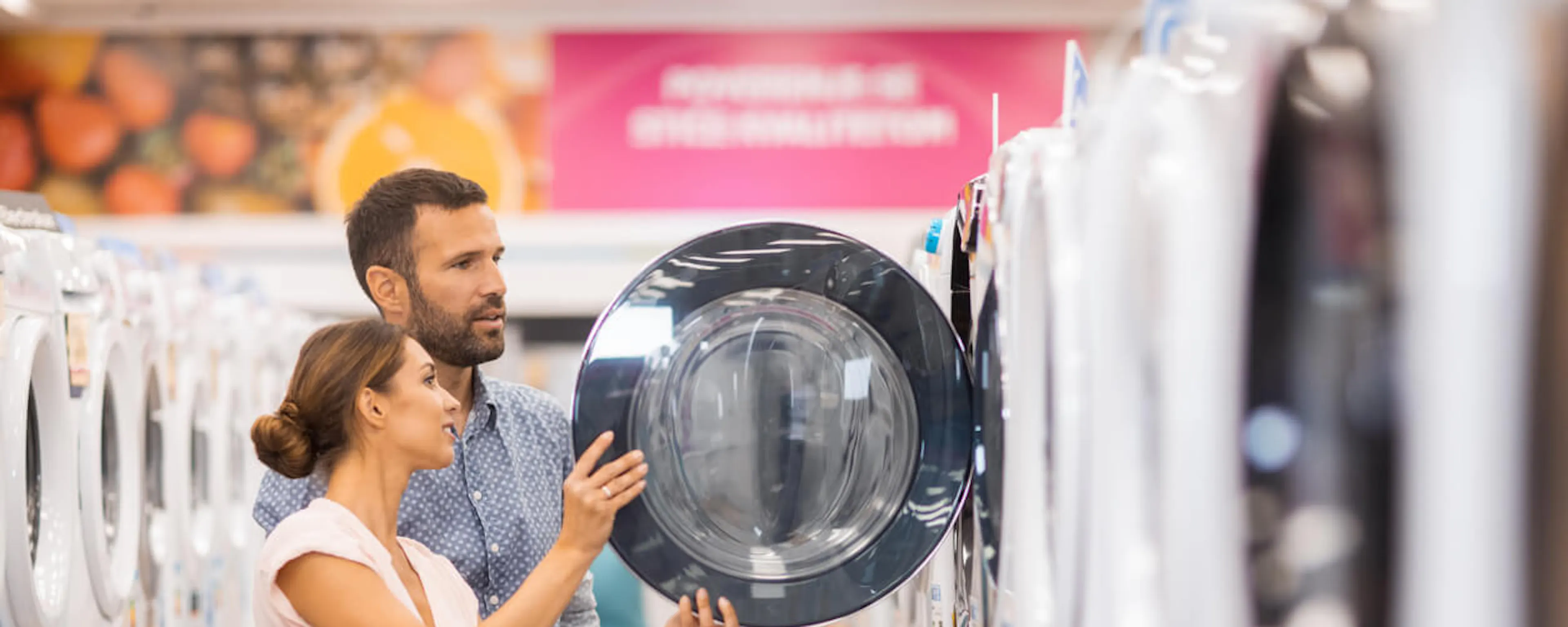 Couple choisissant un lave-linge dans un magasin d'électroménager