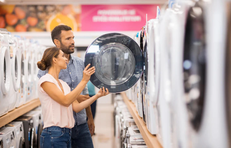 Couple choisissant un lave-linge dans un magasin d'électroménager