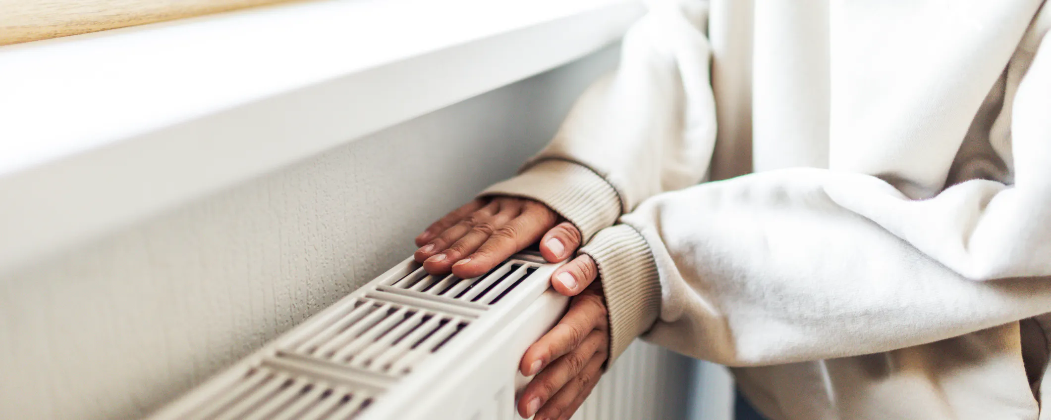 Radiateur chaud en haut et froid en bas : une personne qui pose ses mains sur son radiateur