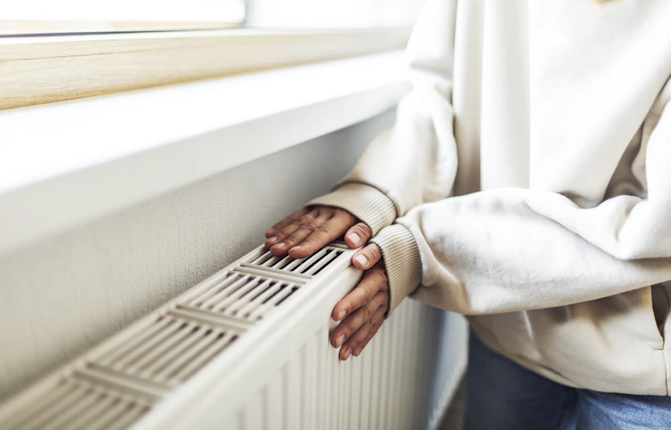 Radiateur chaud en haut et froid en bas : une personne qui pose ses mains sur son radiateur