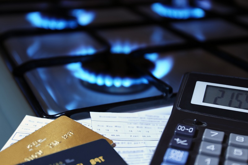 Plaques de cuisson à gaz allumées avec calculatrice et cartes bancaires