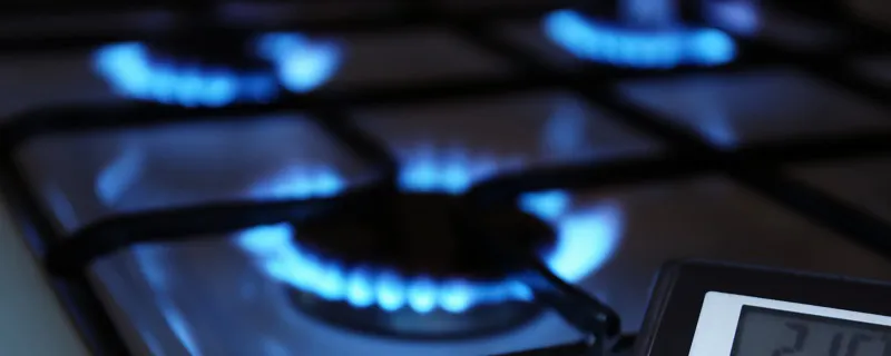Plaques de cuisson à gaz allumées avec calculatrice et cartes bancaires