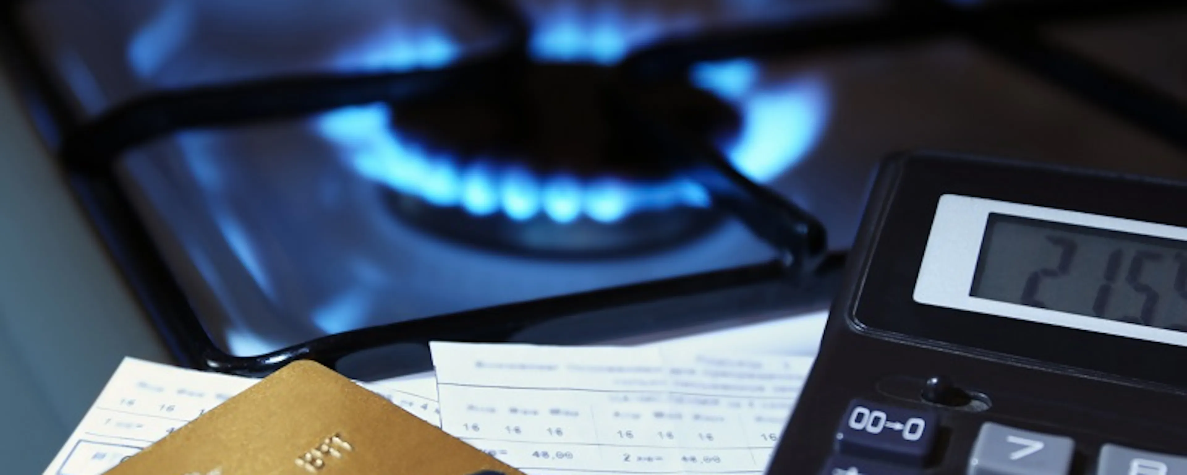 Plaques de cuisson à gaz allumées avec calculatrice et cartes bancaires