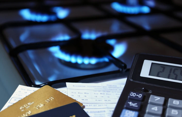 Plaques de cuisson à gaz allumées avec calculatrice et cartes bancaires