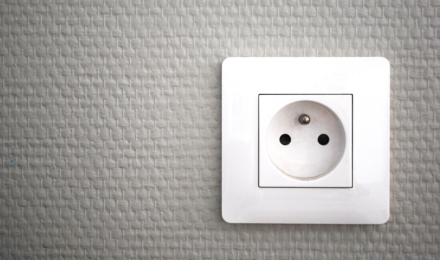 Prise électrique murale blanche sur fond gris texturé