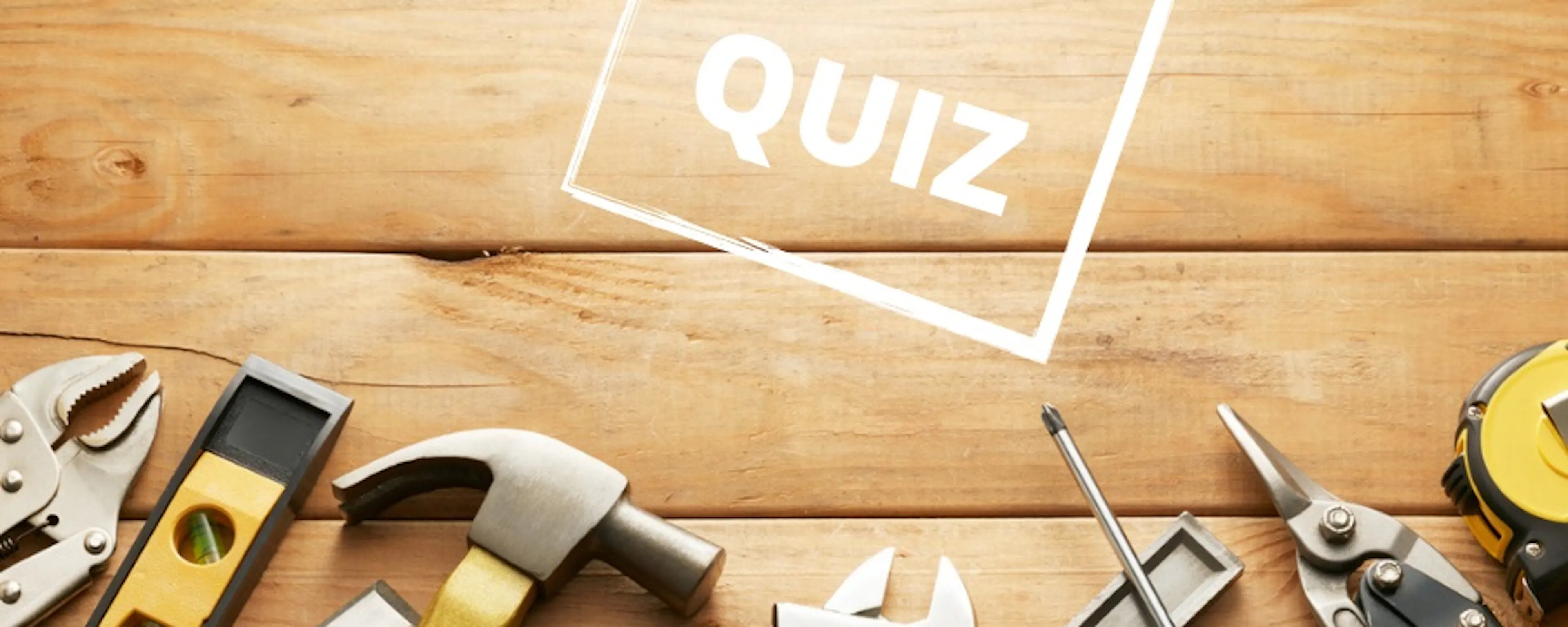 Assortiment d'outils de bricolage sur fond en bois avec le mot QUIZ