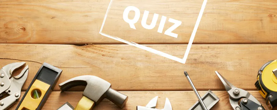 Assortiment d'outils de bricolage sur fond en bois avec le mot QUIZ