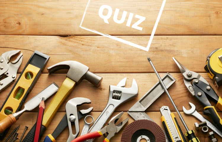 Assortiment d'outils de bricolage sur fond en bois avec le mot QUIZ