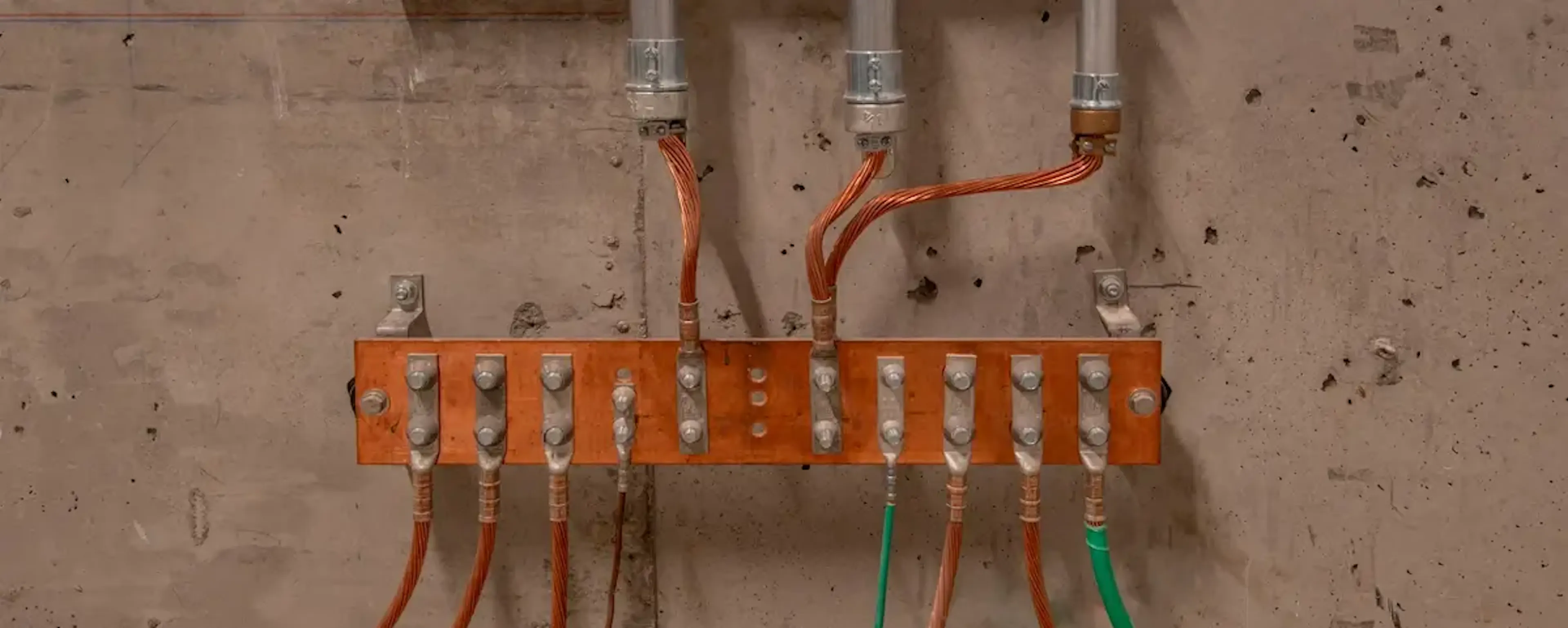 Tableau de distribution électrique avec câbles colorés sur un mur en béton