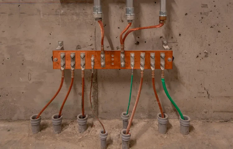 Tableau de distribution électrique avec câbles colorés sur un mur en béton