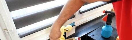 Technicien nettoyant un robinet d'évier noir avec une brosse