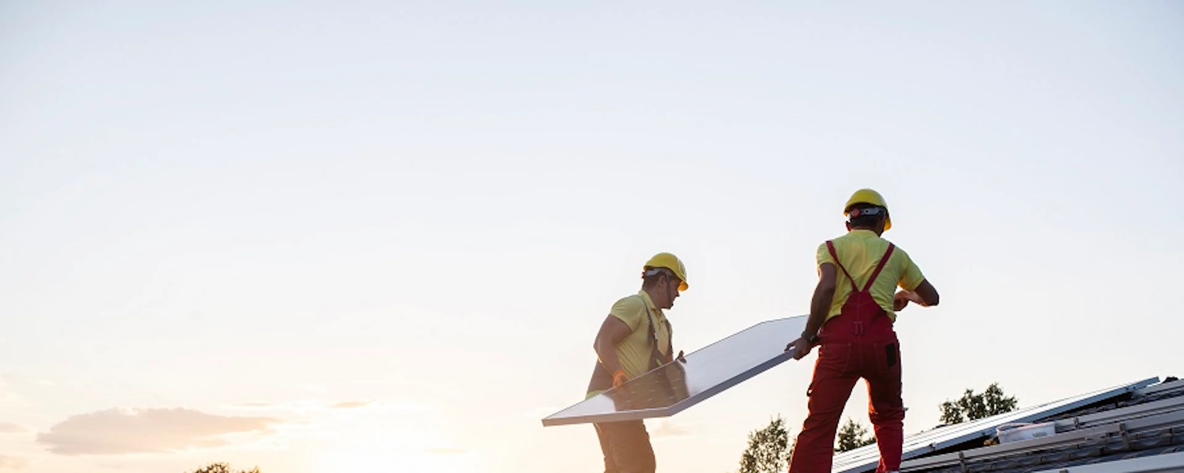 Rangée de panneaux solaires bleus sur toit de maison avec cheminée en briques