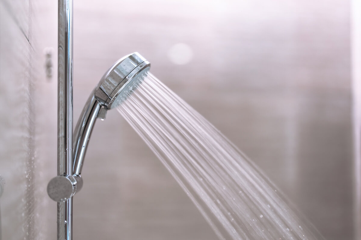Pommeau de douche chromé avec jet d'eau dans une salle de bain
