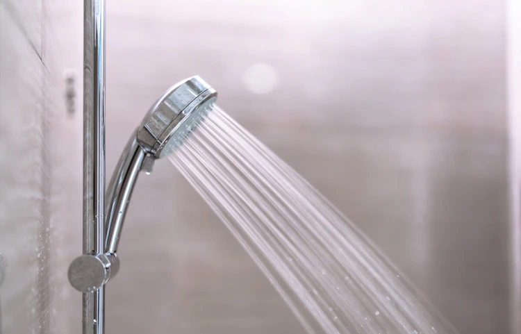 Pommeau de douche chromé avec jet d'eau dans une salle de bain