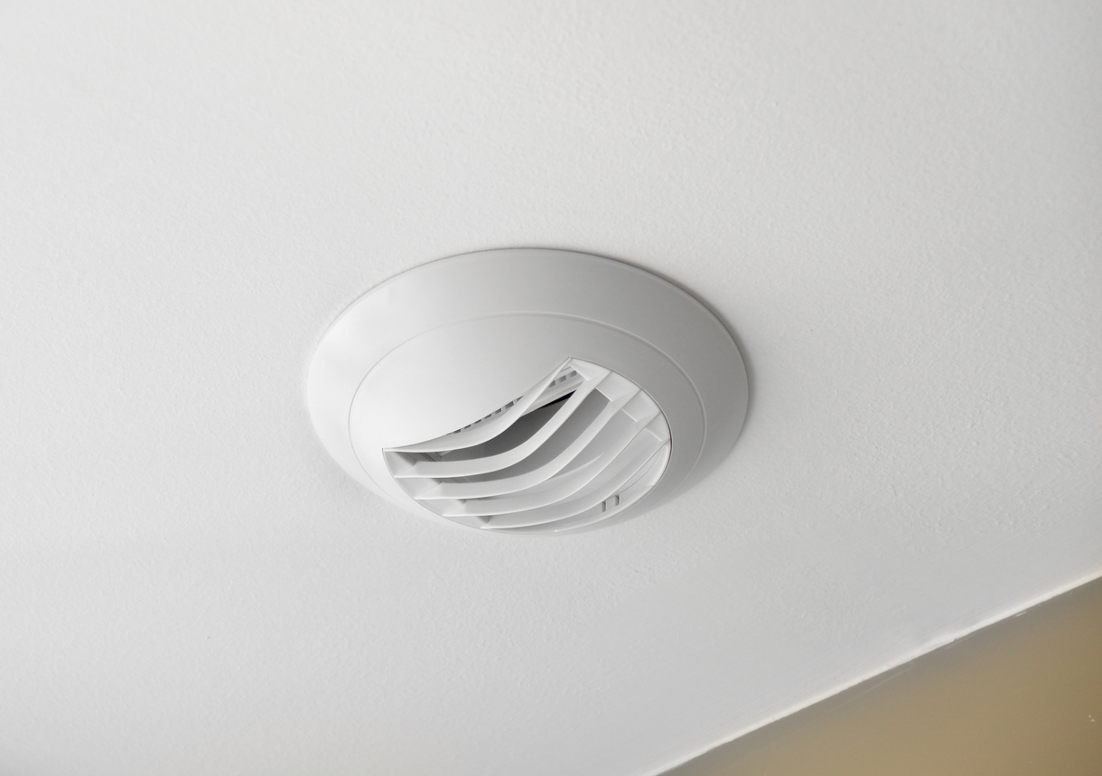 Bouche d'extraction de VMC hygroréglable fixée au plafond d'une salle de bain