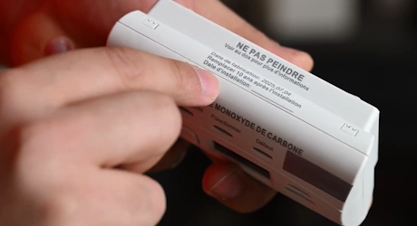 Mains tenant un détecteur avec étiquette ne pas peindre