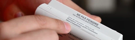 Mains tenant un détecteur avec étiquette ne pas peindre