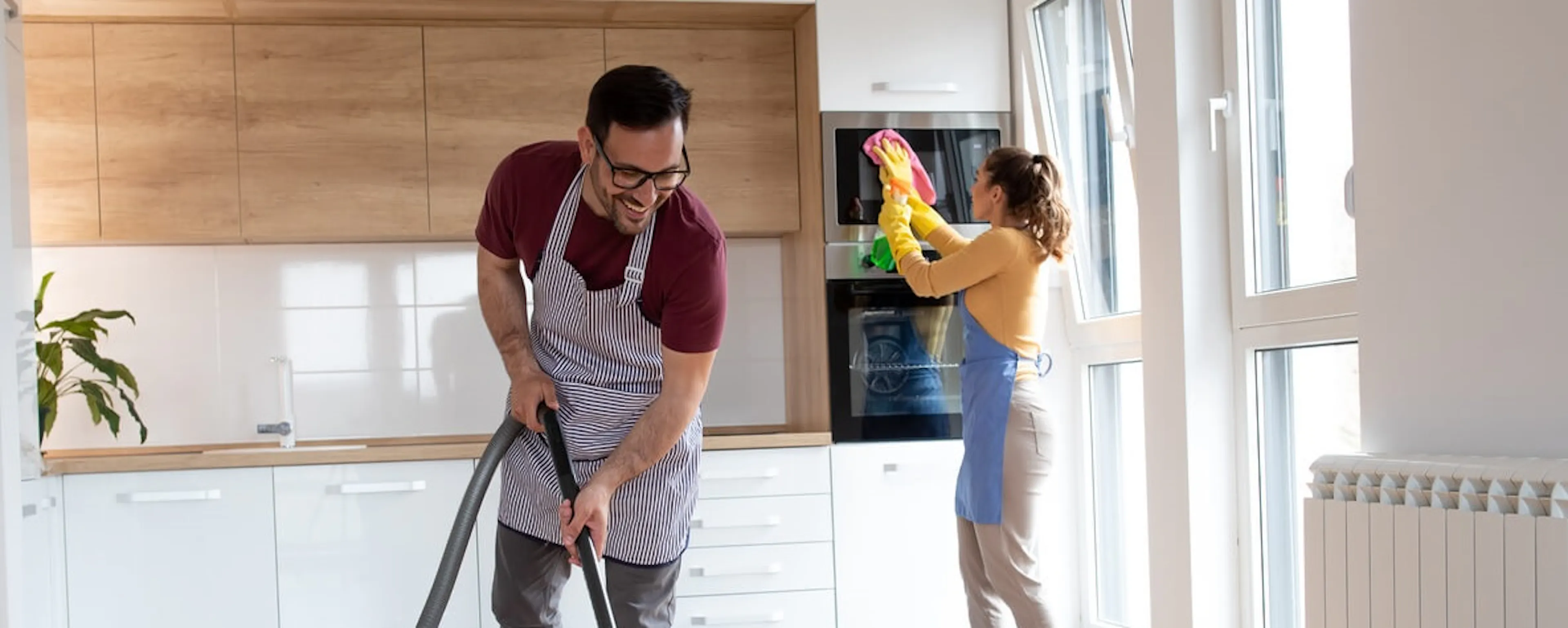 Couple faisant le ménage dans une cuisine moderne et lumineuse