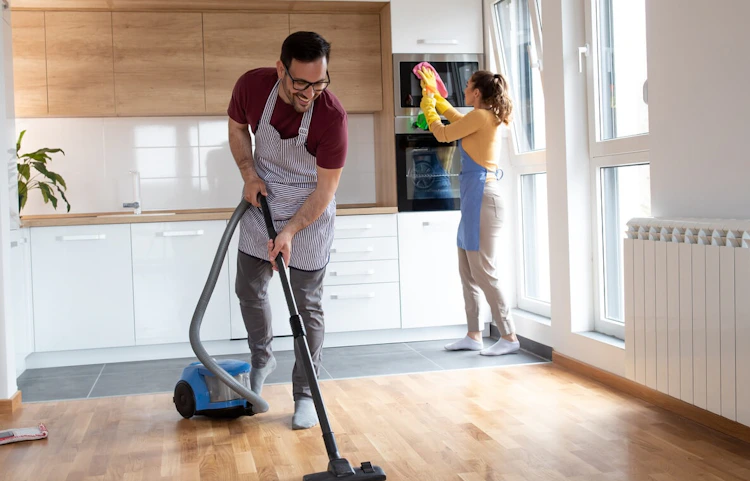 Couple faisant le ménage dans une cuisine moderne et lumineuse