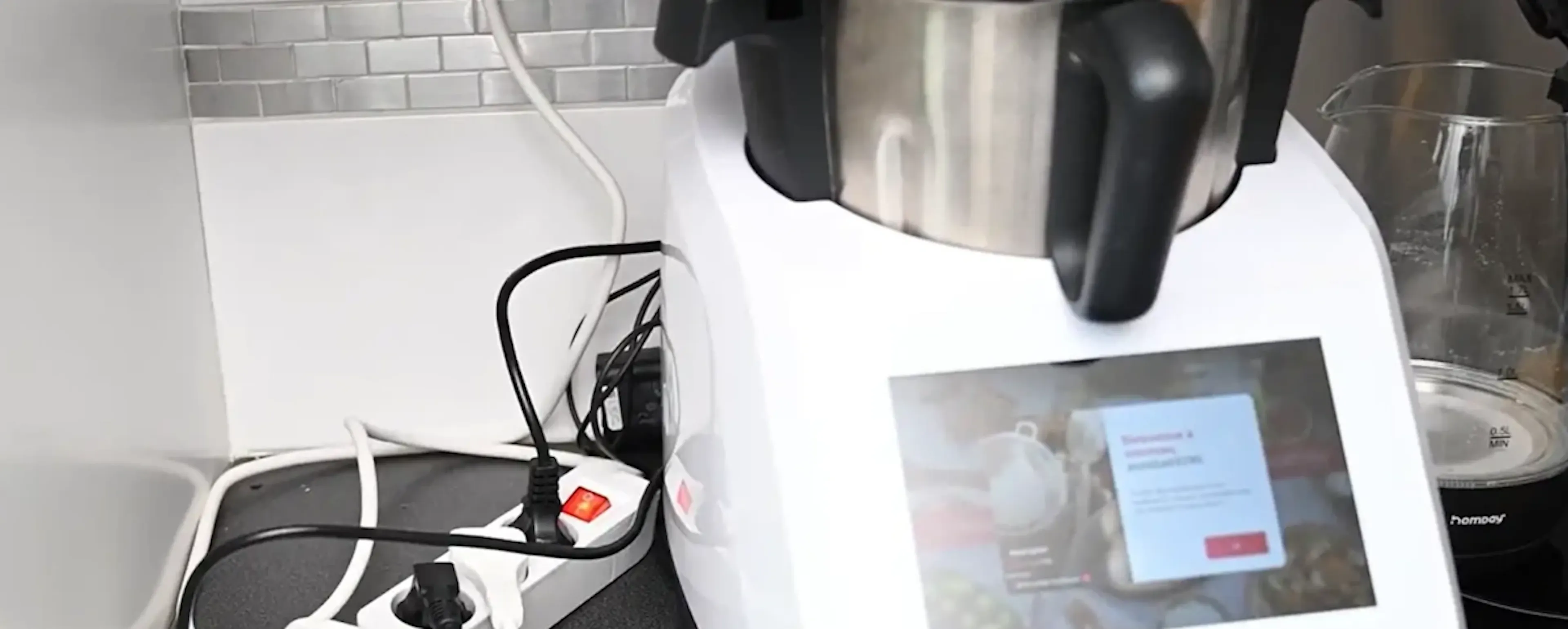 Robot cuiseur posé sur un plan de travail avec une multiprise