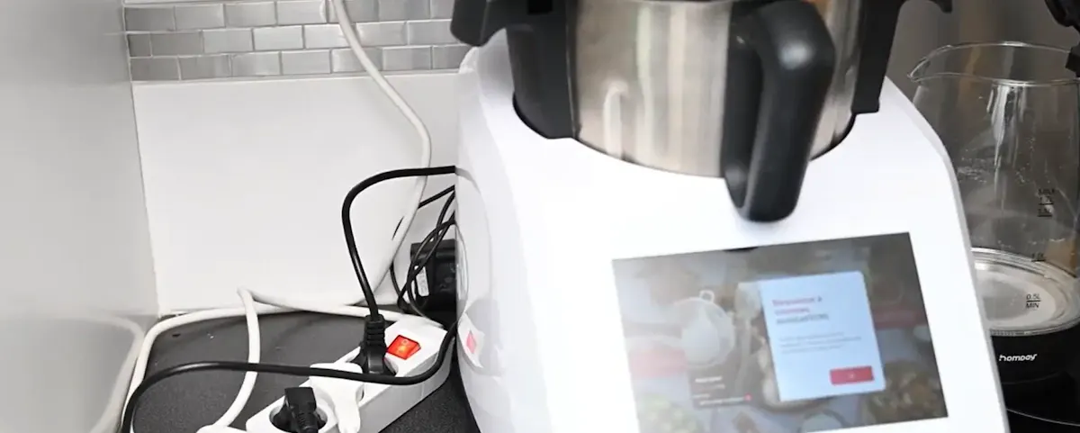 Robot cuiseur posé sur un plan de travail avec une multiprise