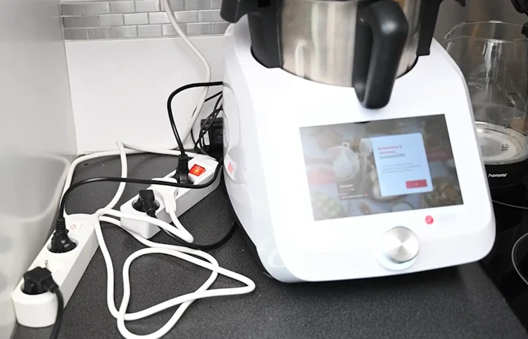 Robot cuiseur posé sur un plan de travail avec une multiprise
