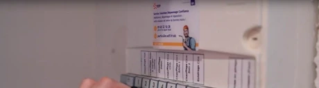 Main manipulant un disjoncteur sur un tableau électrique avec étiquettes