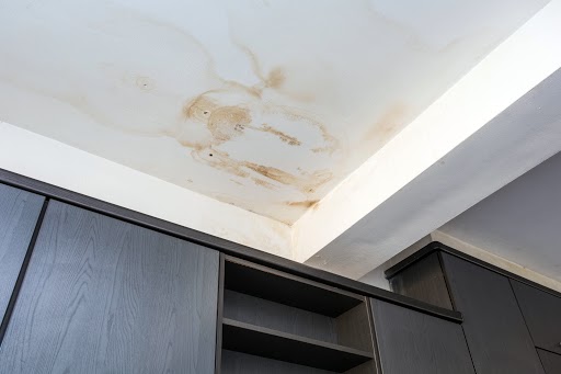 Taches d'humidité et dégâts des eaux sur un plafond blanc