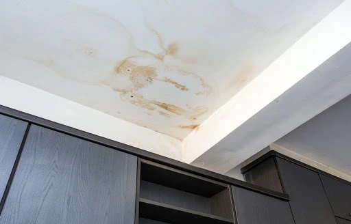Taches d'humidité et dégâts des eaux sur un plafond blanc