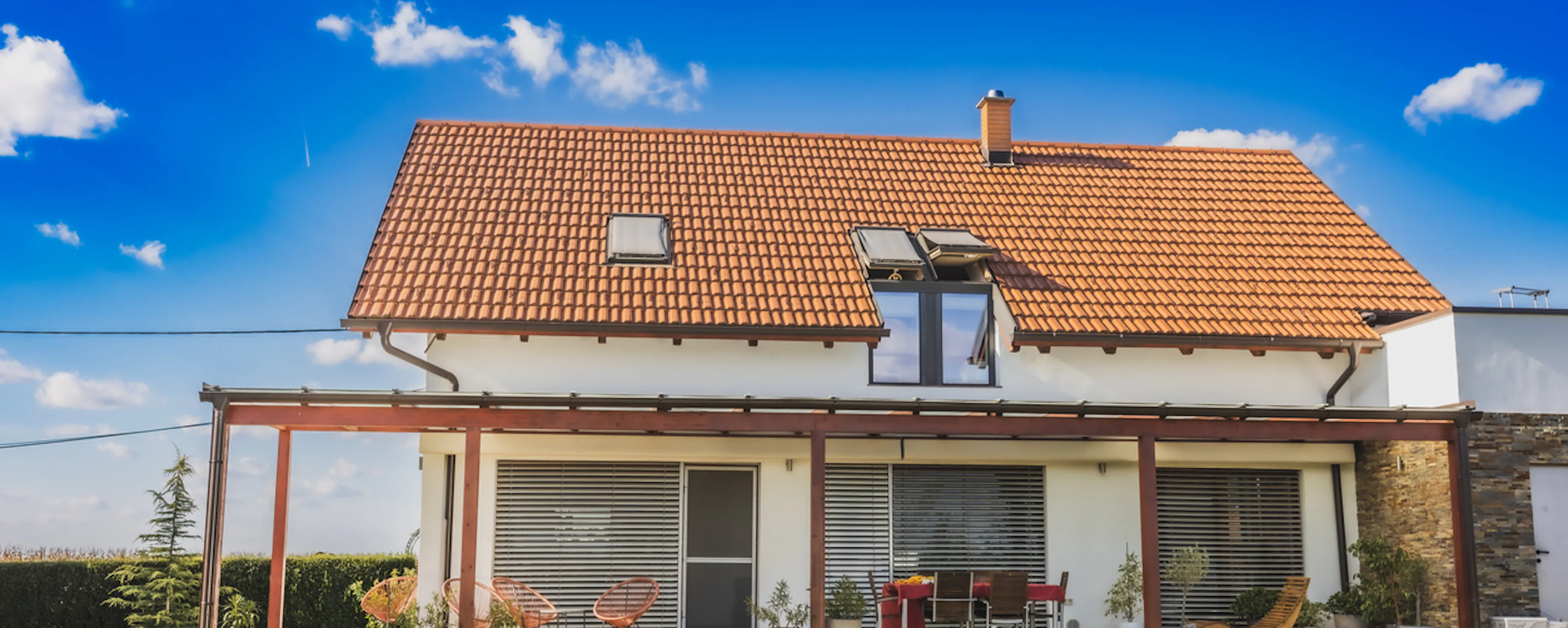 Audit énergétique, différence avec le DPE, à quoi ça sert : photo d'une maison vue depuis son jardin, toit de tuiles, pergola et murs clairs