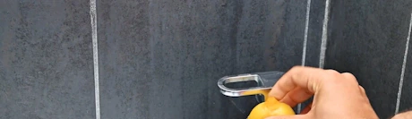 Main frottant un robinet avec un citron et du bicarbonate