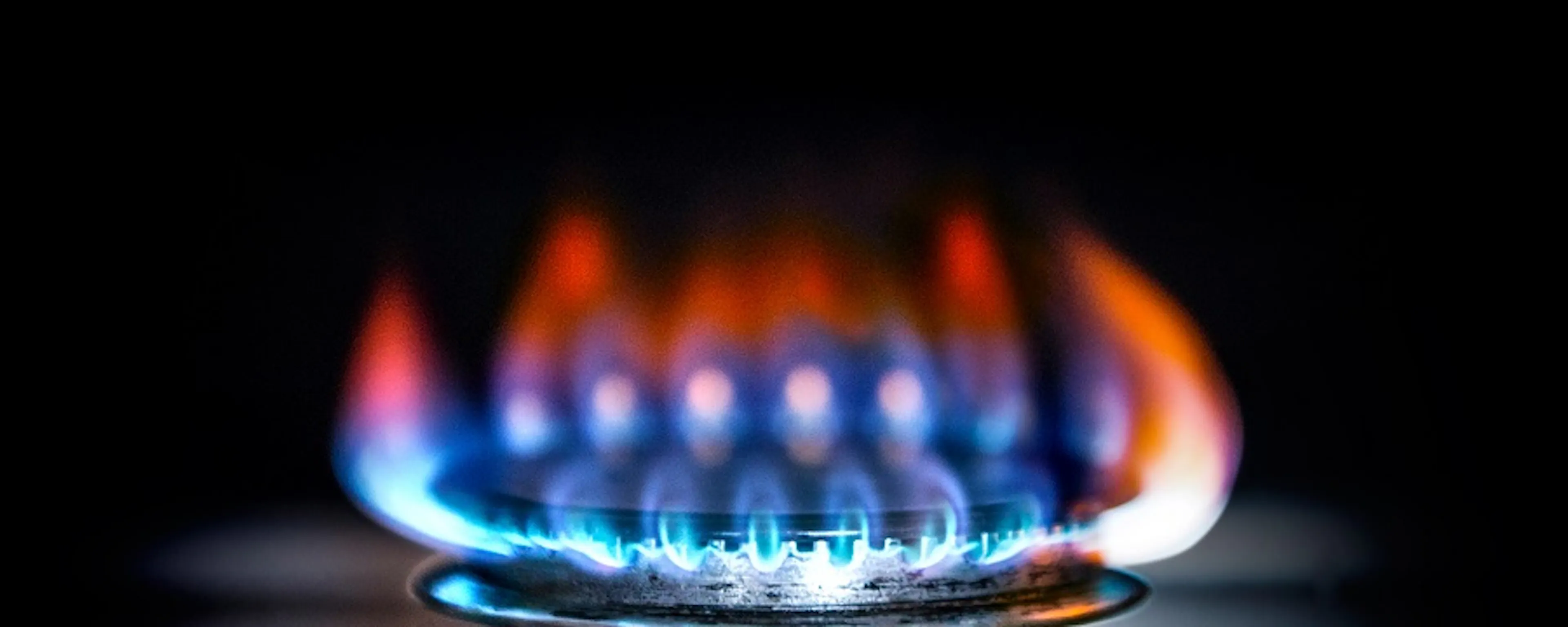 Flamme bleue et orange d'un brûleur de cuisinière à gaz