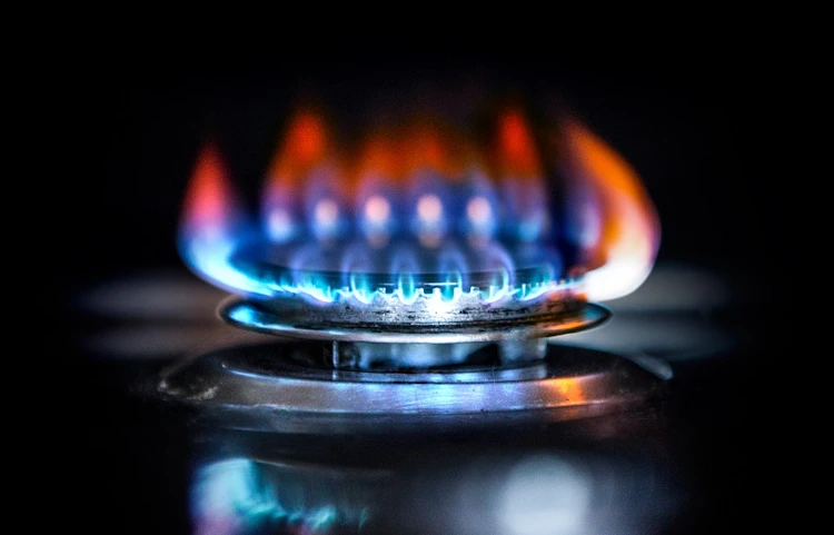 Flamme bleue et orange d'un brûleur de cuisinière à gaz