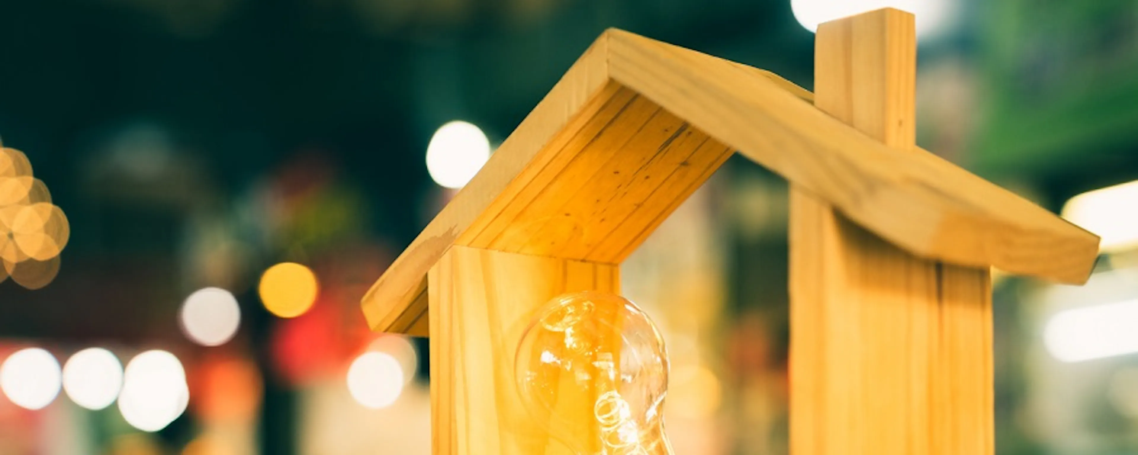 Maquette de maison en bois avec ampoule lumineuse allumée à l'intérieur